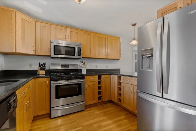 a kitchen with stainless steel appliances granite countertop a refrigerator stove and microwave