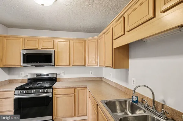 a kitchen with granite countertop a sink stainless steel appliances and cabinets