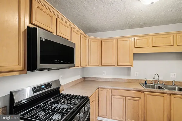a kitchen with stainless steel appliances a sink dishwasher stove microwave and cabinets
