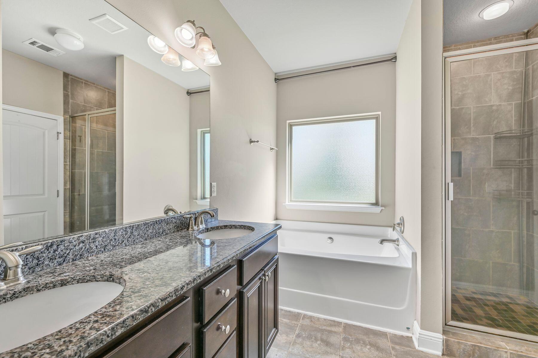 96 Pin Oak Loop Santa Rosa Beach, FL 32459 - Photo 23 of 47 a bathroom with a granite countertop sink mirror and a bathtub