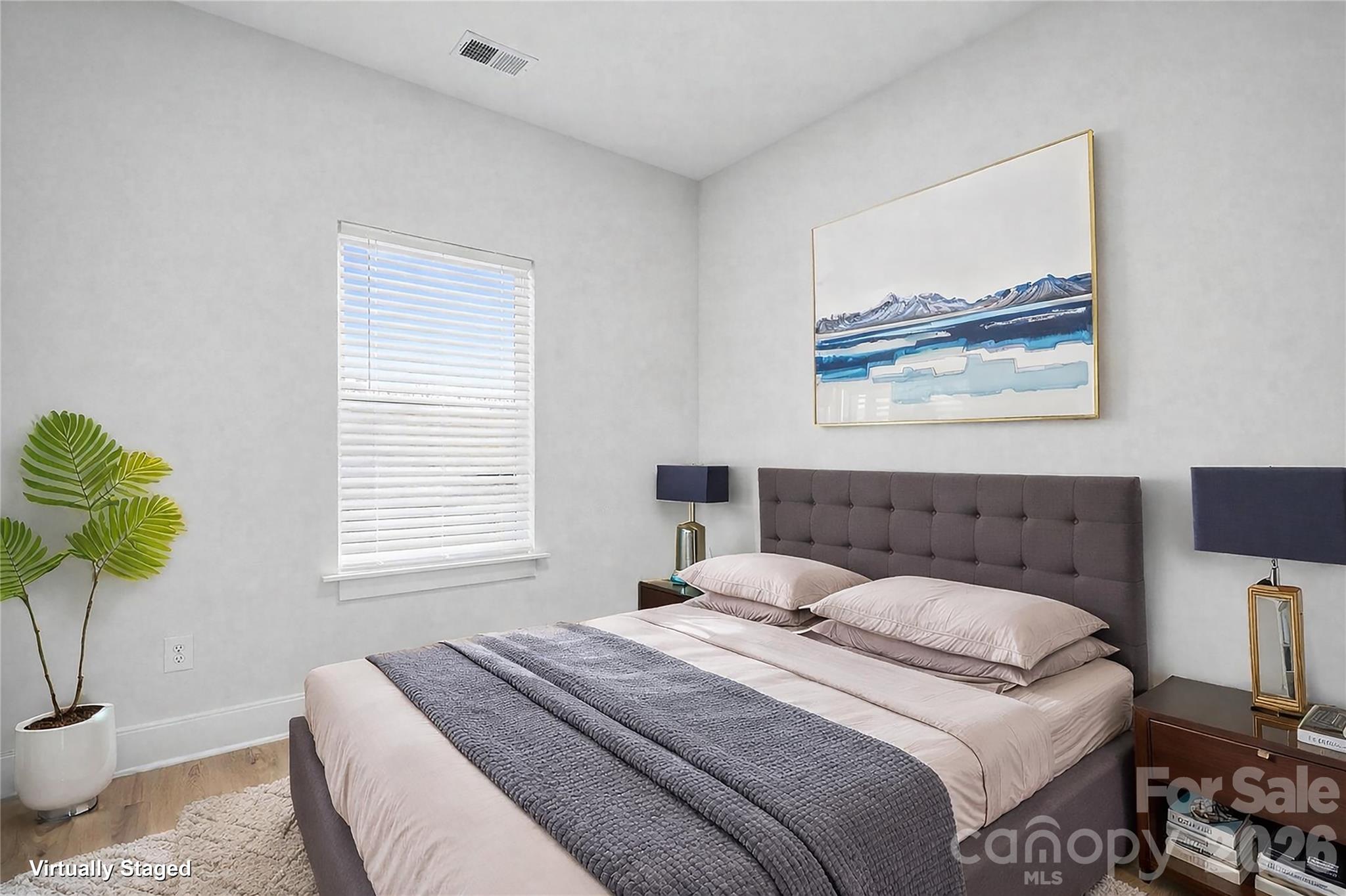 5626 Torrence Street Charlotte, NC 28269 - Photo 14 of 27 a bedroom with a bed and a painting on the wall