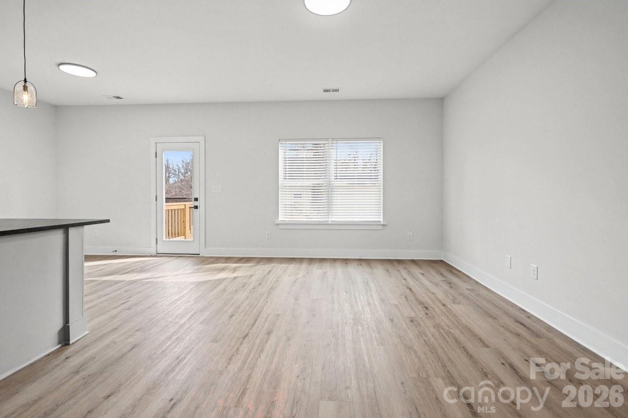 5626 Torrence Street Charlotte, NC 28269 - Photo 18 of 27 an empty room with wooden floor and windows