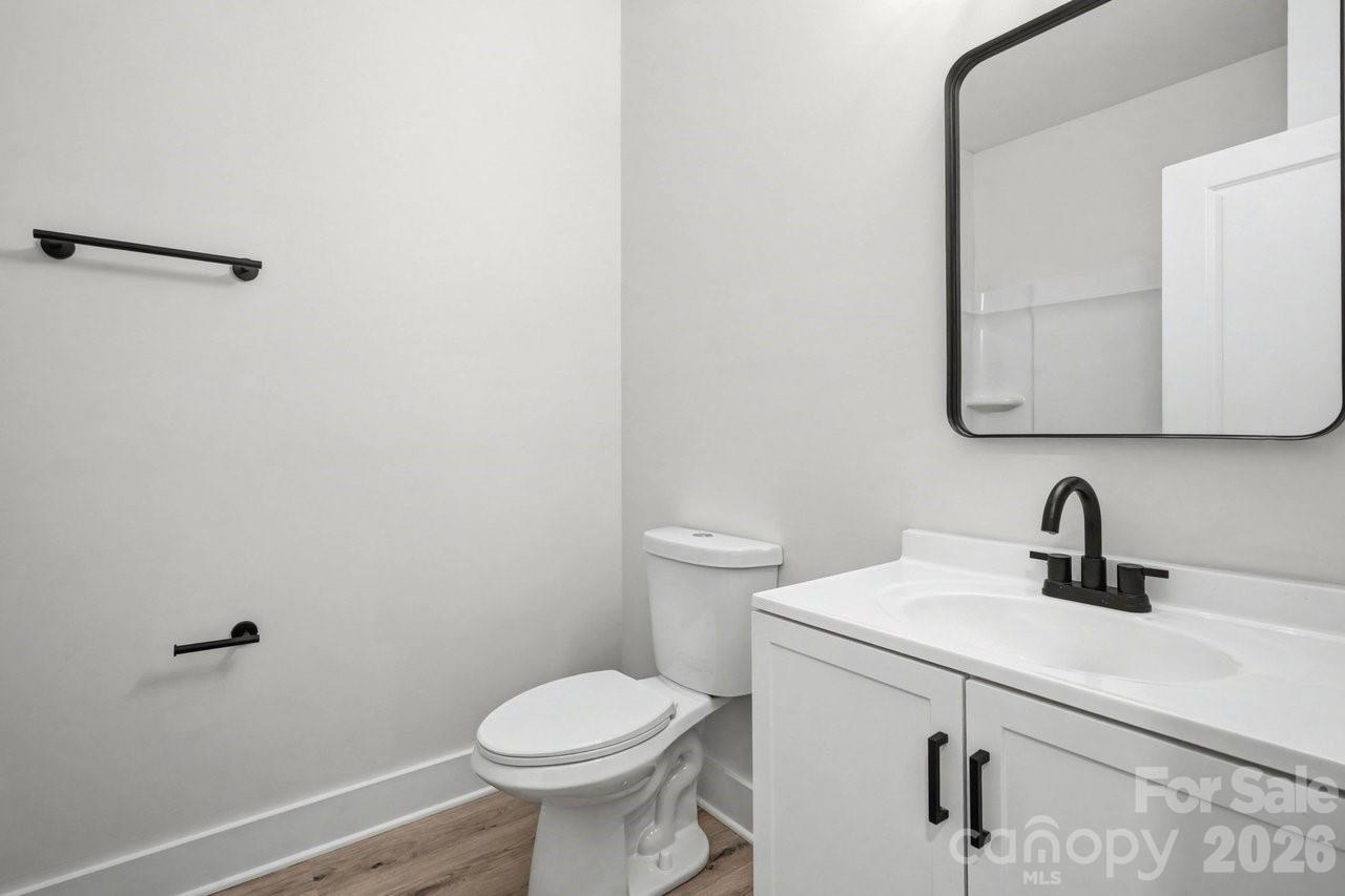 5626 Torrence Street Charlotte, NC 28269 - Photo 22 of 27 a bathroom with a sink a toilet and mirror