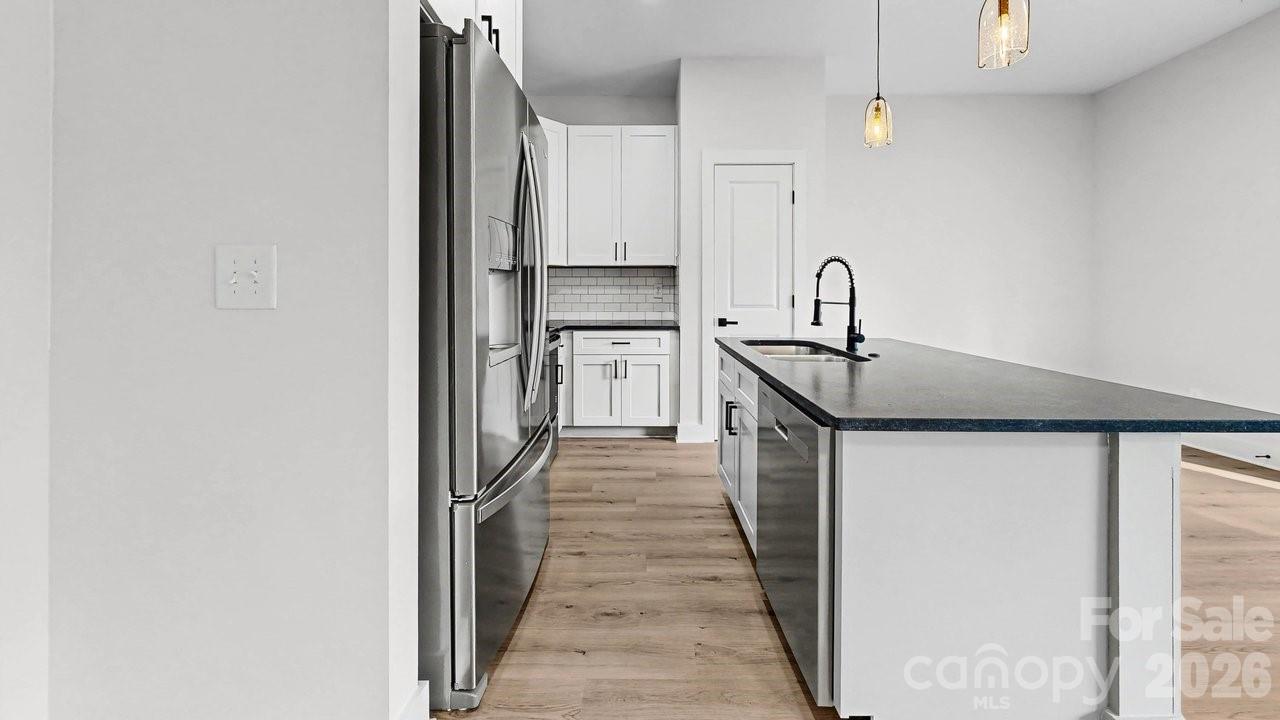 5626 Torrence Street Charlotte, NC 28269 - Photo 6 of 27 a kitchen with stainless steel appliances granite countertop a sink and dishwasher