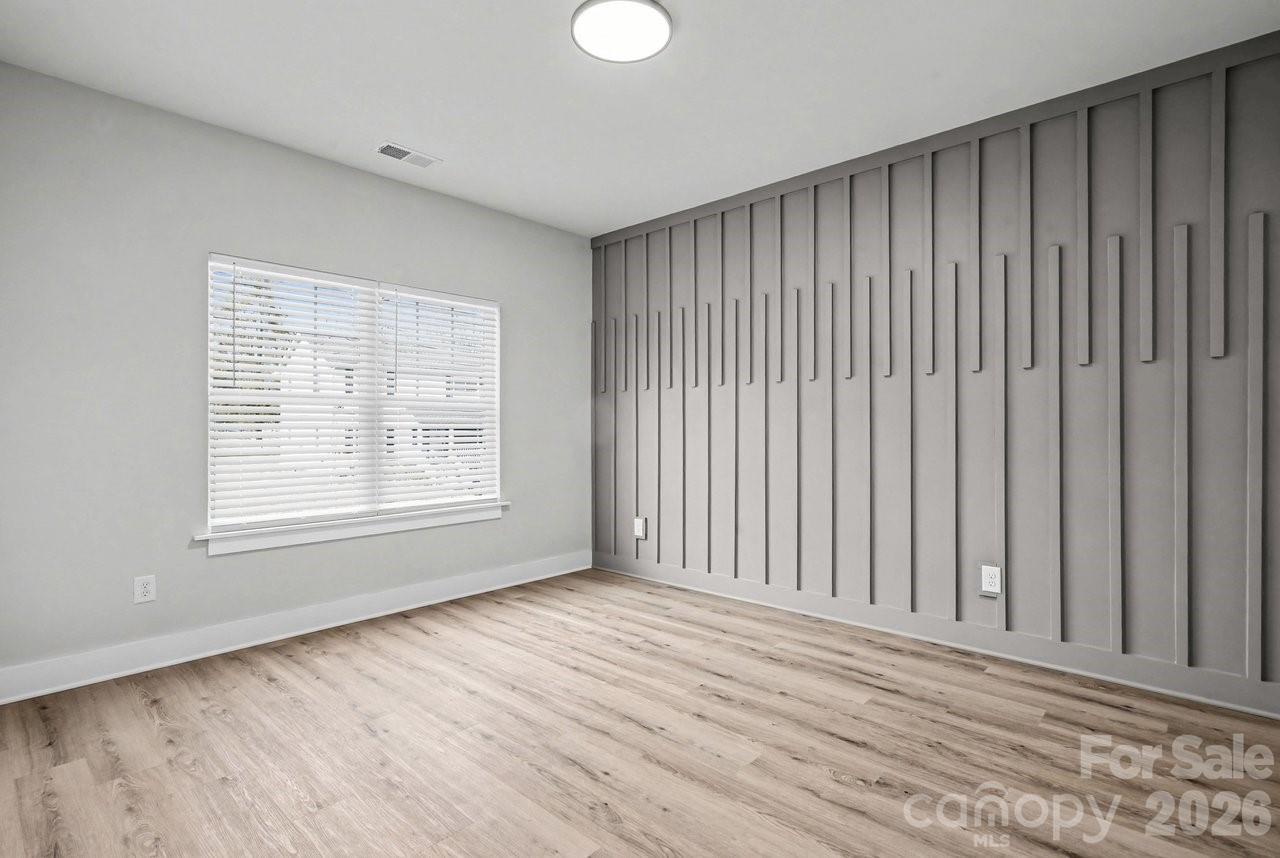 5626 Torrence Street Charlotte, NC 28269 - Photo 10 of 27 an empty room with wooden floor and windows