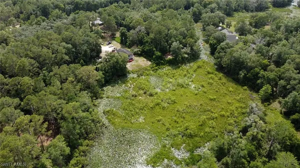 an aerial view of residential houses with outdoor space and trees