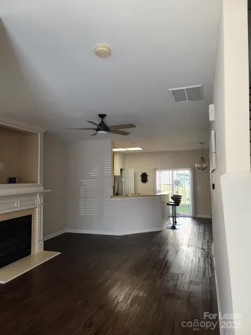 a view of a room with wooden floor a fireplace and window