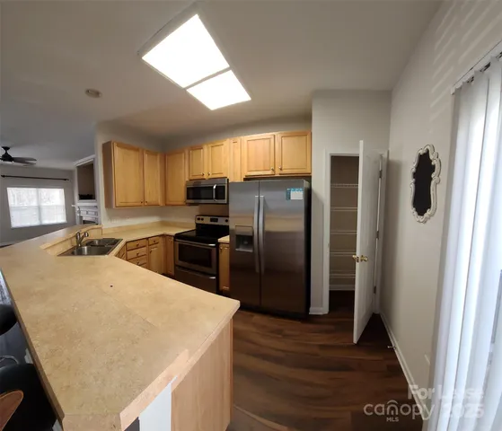 a kitchen with stainless steel appliances granite countertop a refrigerator a stove a sink and a microwave