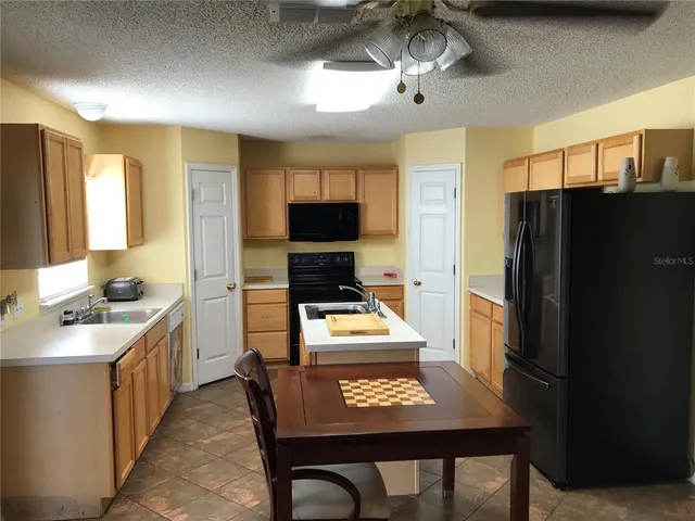 a kitchen with stainless steel appliances granite countertop a refrigerator stove microwave and sink