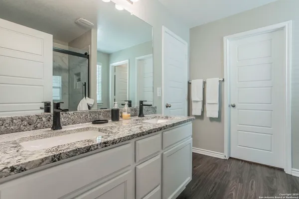 a bathroom with a granite countertop sink mirror vanity and toilet
