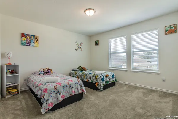 a bedroom with a bed a dresser and wooden floor