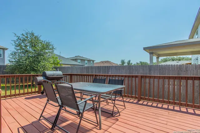 a view of a house with backyard wooden deck and a yard
