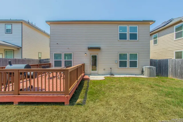 a view of a roof deck with chair and wooden fence