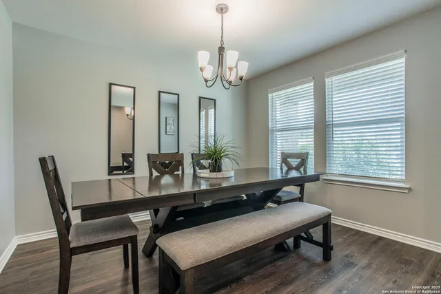 a kitchen with stainless steel appliances granite countertop a refrigerator a sink dishwasher a stove and white countertops with wooden floor