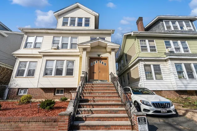a front view of a residential apartment building with a yard