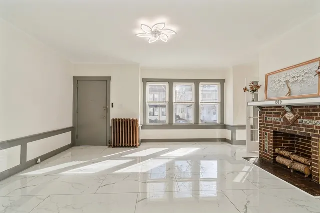 a view of an empty room with a fireplace and a window