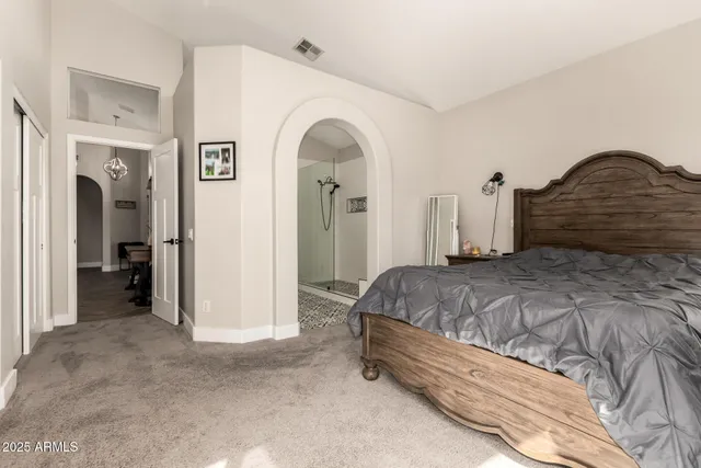 a spacious bedroom with a bed and a car parked in it