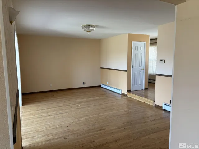 an empty room with wooden floor and entrance