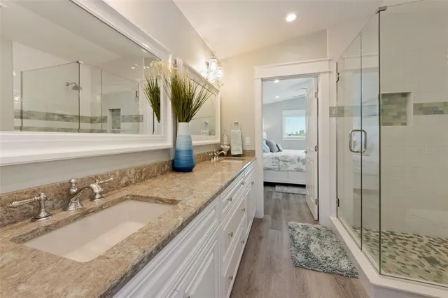 a bathroom with a granite countertop sink and a mirror