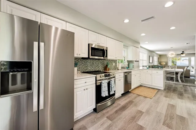 a kitchen with a refrigerator a sink and a microwave