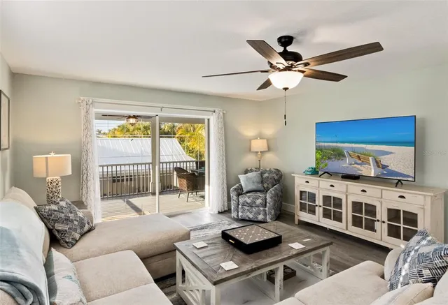 a living room with furniture a flat screen tv and a window
