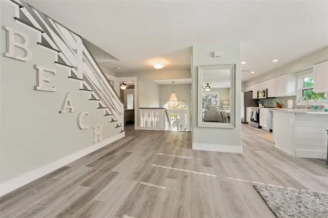 a view of a living room and kitchen with stainless steel appliances