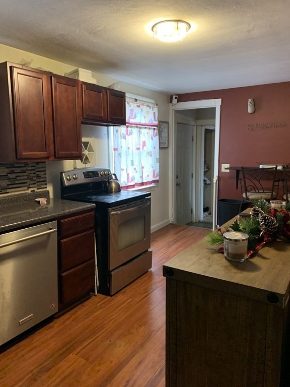 133 Regal Street Springfield, MA 01118 - Photo 6 of 18 a kitchen with kitchen island granite countertop a sink cabinets and wooden floor
