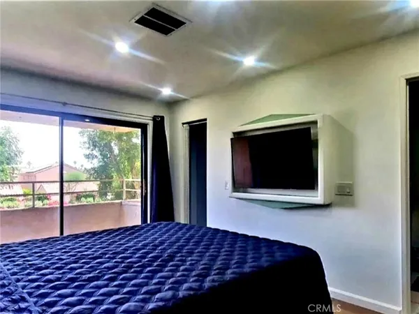a bedroom with a bed and a flat screen tv