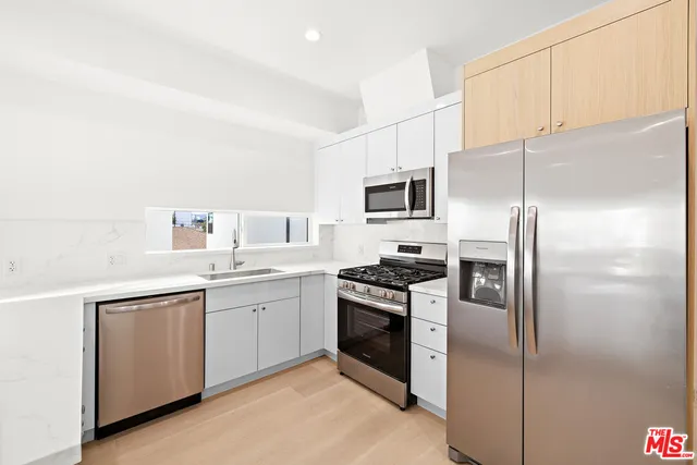 a kitchen with a sink stainless steel appliances and cabinets