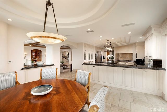 a large kitchen with granite countertop a large counter top appliances and cabinets