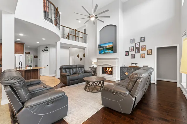 a living room with furniture a fireplace and a chandelier