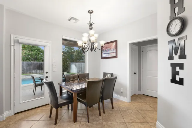 a view of a dining room with furniture and a chandelier