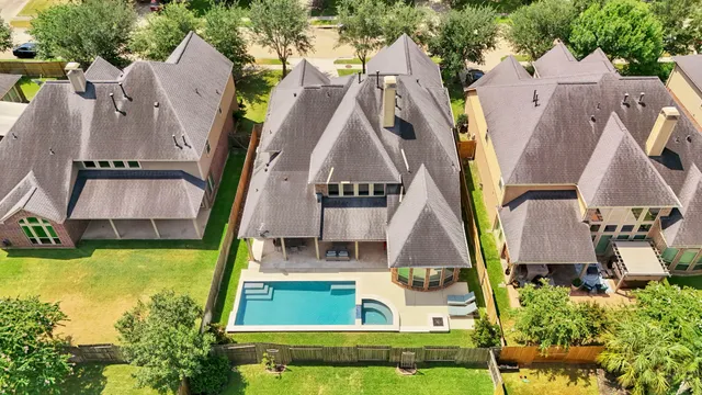 an aerial view of residential houses with outdoor space and swimming pool