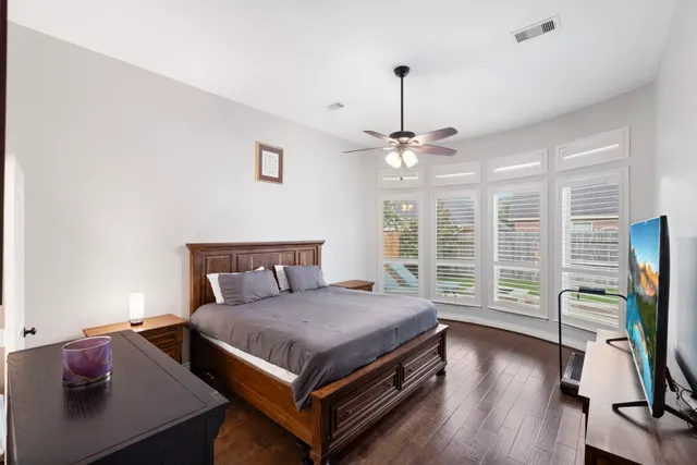 a bedroom with a bed and a flat tv screen on a dresser