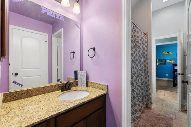 a bathroom with a granite countertop sink a mirror and a shower