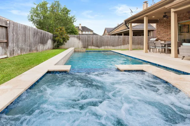 a view of a house with a yard and wooden fence