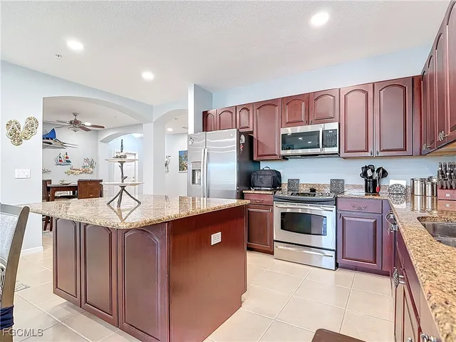 a kitchen with stainless steel appliances granite countertop a stove top oven a sink dishwasher and a refrigerator