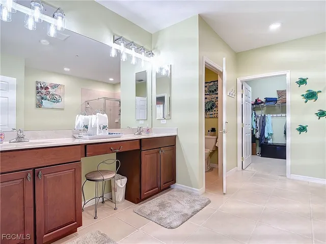 a spacious bathroom with a granite countertop sink a mirror and a shower