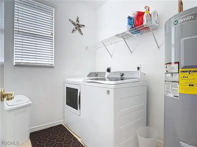 a utility room with cabinets washer and dryer