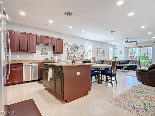 a kitchen with stainless steel appliances granite countertop a stove a sink a oven a dining table and chairs