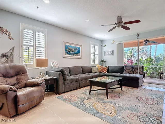 a living room with furniture a large window and a dining table