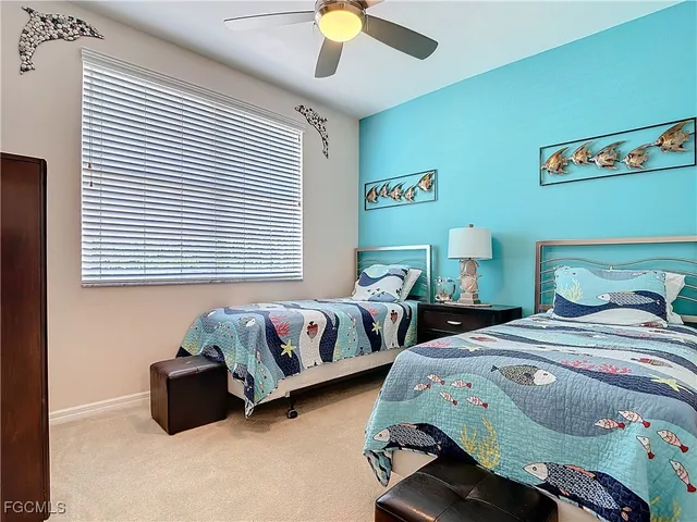 a bedroom with two beds and a chandelier