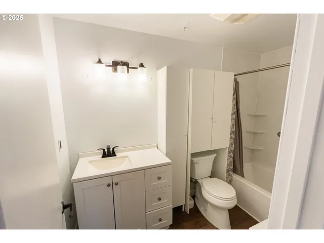 a bathroom with a toilet a sink a mirror and a shower