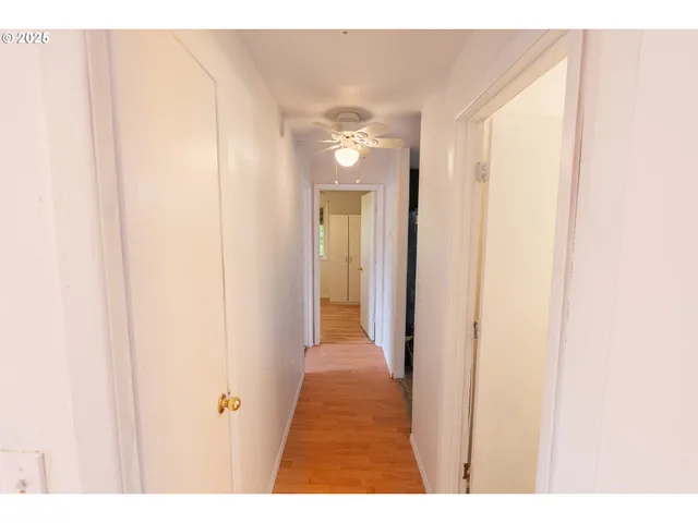 a view of a hallway with wooden floor