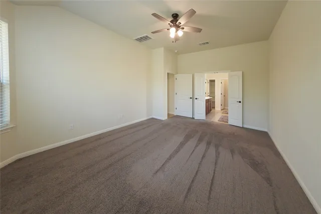 a view of empty room with a ceiling fan and window