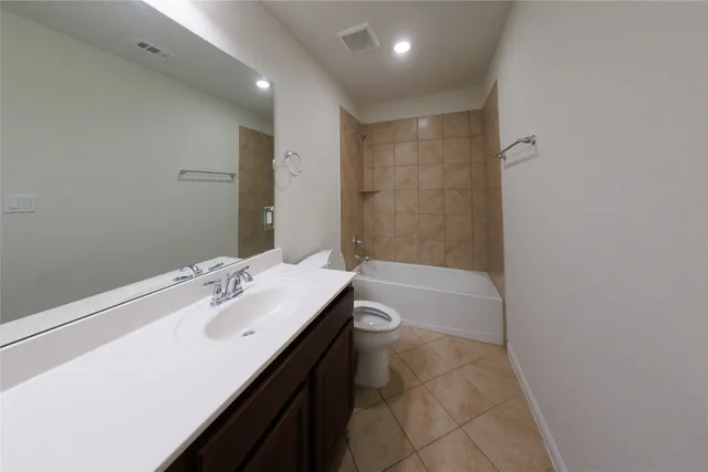 a bathroom with a tub sink vanity granite and mirror