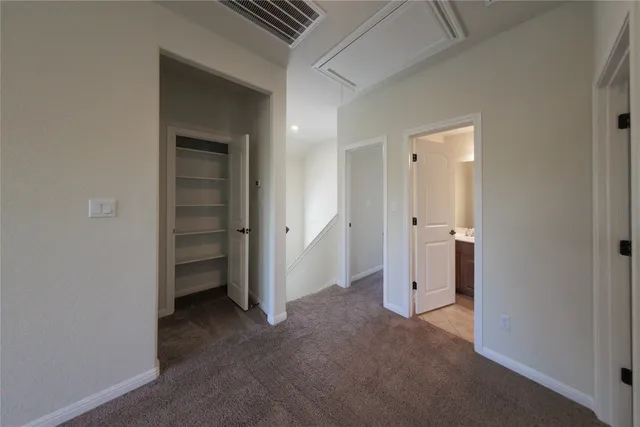 an empty room with closet and a bathroom