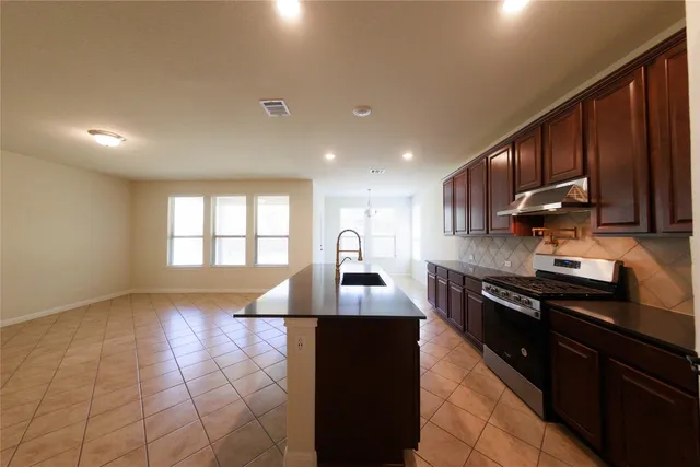 a kitchen with stainless steel appliances granite countertop a sink stove and cabinets