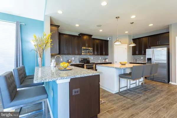 a kitchen with granite countertop a refrigerator and a stove top oven