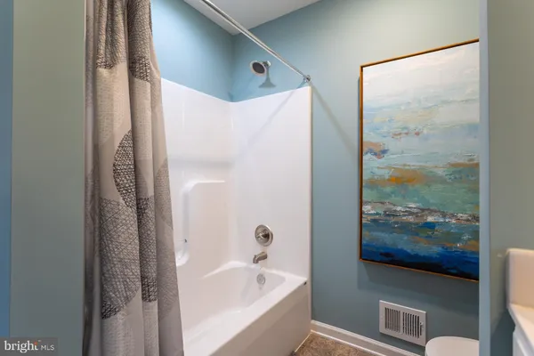 a bathroom with bathtub and glass door